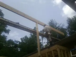 Carpenter setting a ridge beam over a new addition frame — Ice Dam Removal by Roofing Brothers in Nemaha