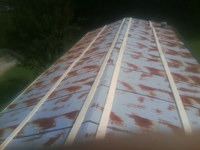 Rusted metal roof panels with new wood purlins before replacement — Storm Damage Roof Repair in Nemaha by Roofing Brothers