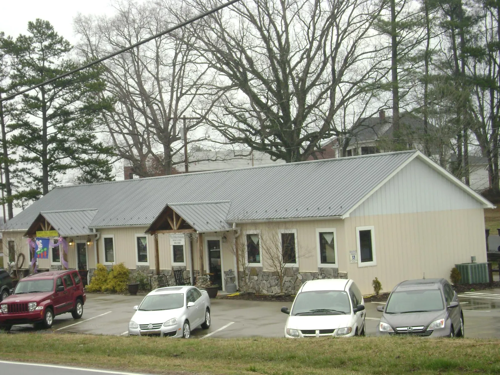 Gray metal roof with timber entry brackets on a small commercial building in Nemaha