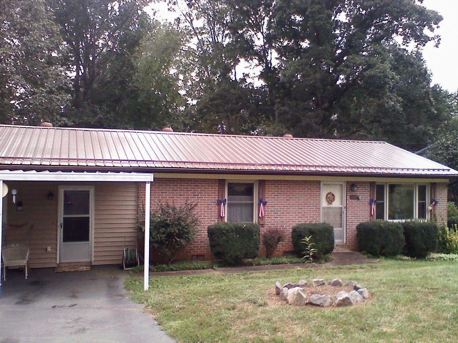 Bronze metal roof and carport on a brick ranch home — Roof Repair work by our crew in Nemaha